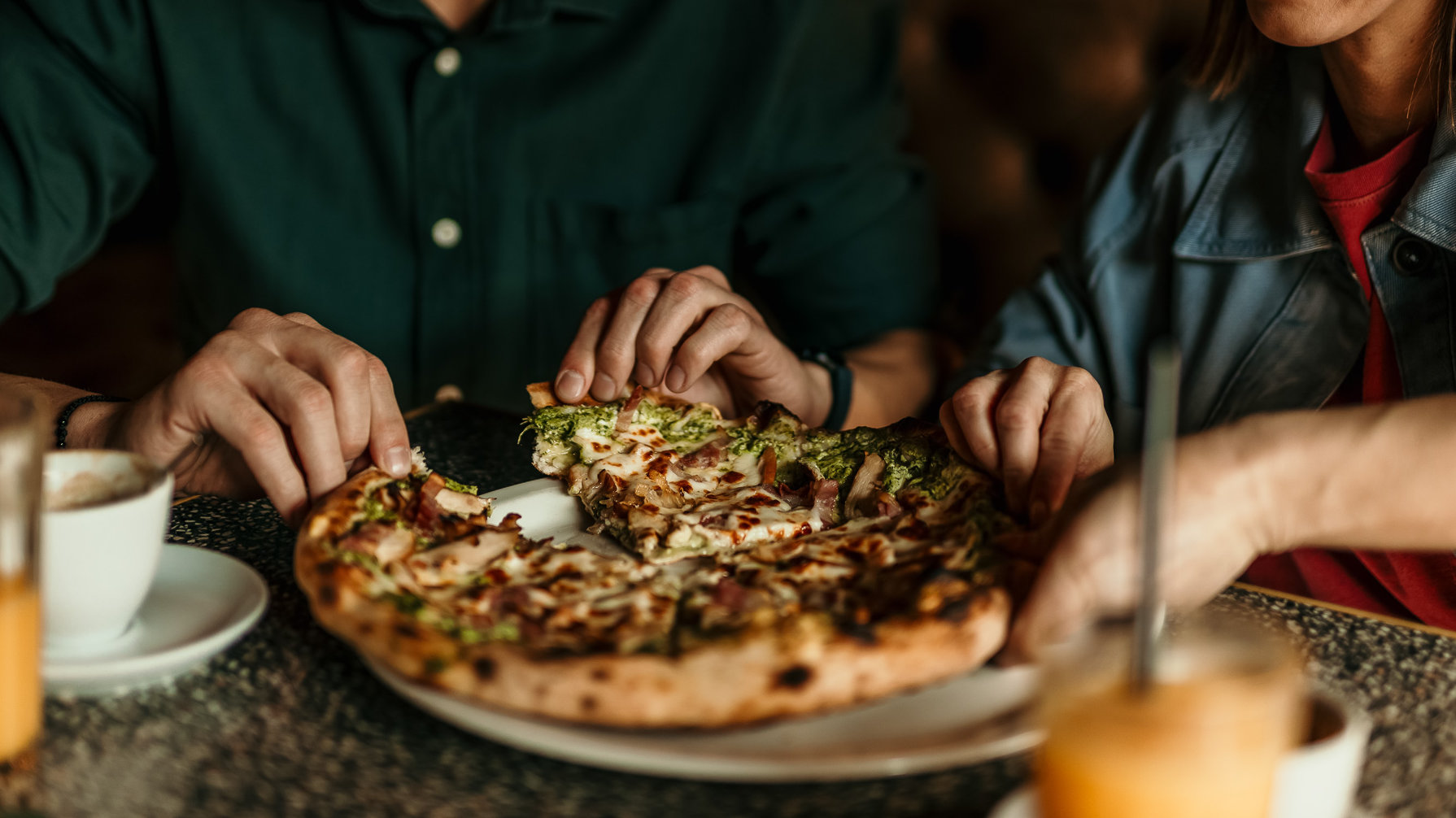 Friends sharing a pizza at an Oakland restaurant